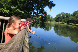 two kids with fishing poles at a lake