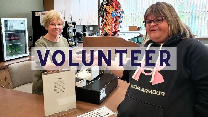 Friends' bookstore and cafe volunteer helping patron with a purchase